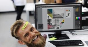man smiling by his monitor
